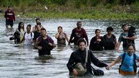 Para migran, sebagian besar dari Venezuela, menyeberangi sungai Tuquesa setelah melakukan perjalanan melalui Darien Gap, di Bajo Chiquito, Panama, Rabu (4/10/2023).  