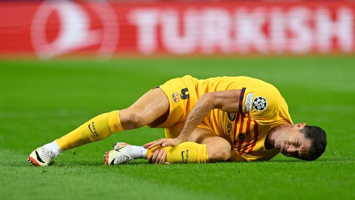 Barcelonas Polish forward #09 Robert Lewandowski lies on the pitch after a fall during the UEFA Champions League 1st round day 2 group H football match between FC Porto and FC Barcelona at the Dragao stadium in Porto on October 4, 2023. (Photo by Patricia DE MELO MOREIRA / AFP)