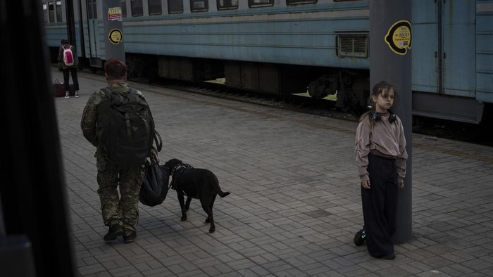 A Ukrainian serviceman hugs his wife and the daughter at the railway station in Sloviansk, Donetsk region, Ukraine on Tuesday, Sept. 12, 2023. The train that runs from Ukraine's capital, Kyiv, to the city of Kramatorsk in the east stands apart from others in Ukraine. It is shrouded in solemn silence as passengers anticipate their final destination — in front-line areas where battles rage between Ukrainian and Russian forces. (AP Photo/Hanna Arhirova)