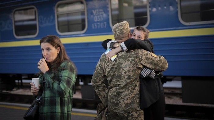 A Ukrainian serviceman hugs his wife and the daughter at the railway station in Sloviansk, Donetsk region, Ukraine on Tuesday, Sept. 12, 2023. The train that runs from Ukraine's capital, Kyiv, to the city of Kramatorsk in the east stands apart from others in Ukraine. It is shrouded in solemn silence as passengers anticipate their final destination — in front-line areas where battles rage between Ukrainian and Russian forces. (AP Photo/Hanna Arhirova)