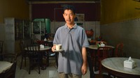 Pemilik Warung Kopi (Warkop) Nan Yo, Victor Bostani (45) berpose dengan secangkir kopi di warungnya.