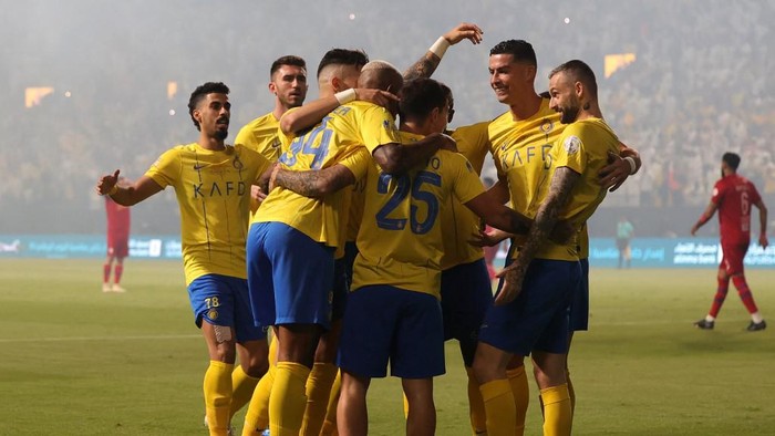 Nassrs Portuguese midfielder #25 Otavio celebrates with teammates after scoring the first goal during the Saudi Pro League football match between Al-Nassr and Abha at the King Saud University Stadium in Riyadh on October 6, 2023. (Photo by Fayez Nureldine / AFP)