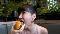 Mampir ke restoran Karen’s Diner, Lucinta pesan burger dan menyantap burger tersebut dengan lahap. Foto: Instagram/Pool