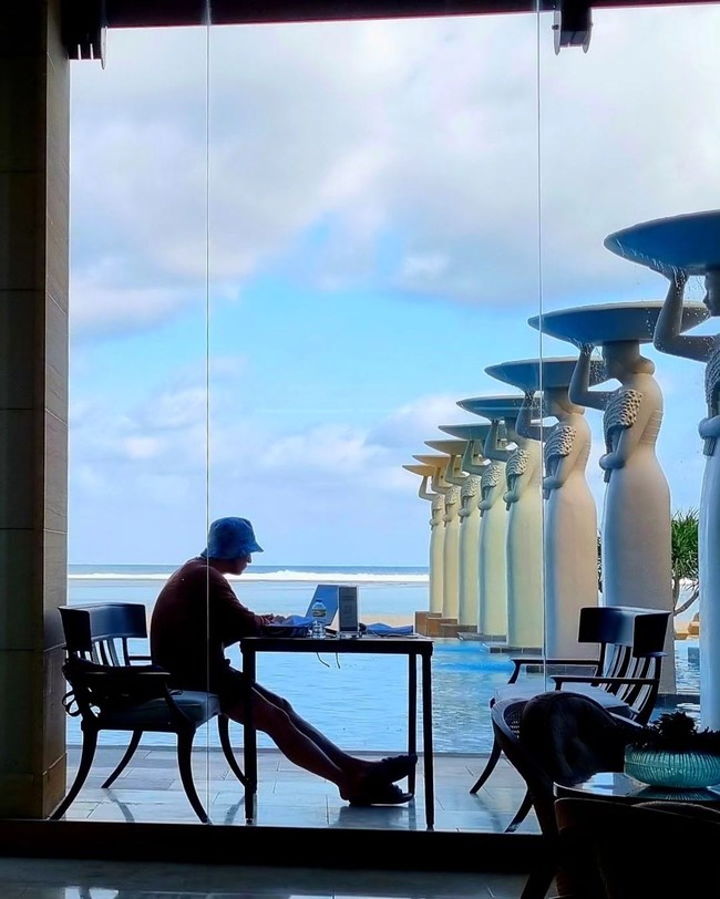 Hari-hari membuka laptop. Son Sukku juga menyorot pemandangan patung dan kolam renang yang menjadi ikon Hotel Mulia Bali dan sering terlihat di akun Instagram artis Korea yang liburan ke Pulau Dewata. Foto: dok. Instagram @sonsukku