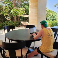 Sejumlah penggemar Indonesia menyebut Son Sukku sudah melokal. Dia tampak bekerja di depan laptopnya memakai kaos kutang berwarna kuning yang dibeli di gerai Billabong Seminyak dan beralas kaki sendal. Foto: dok. Instagram @sonsukku