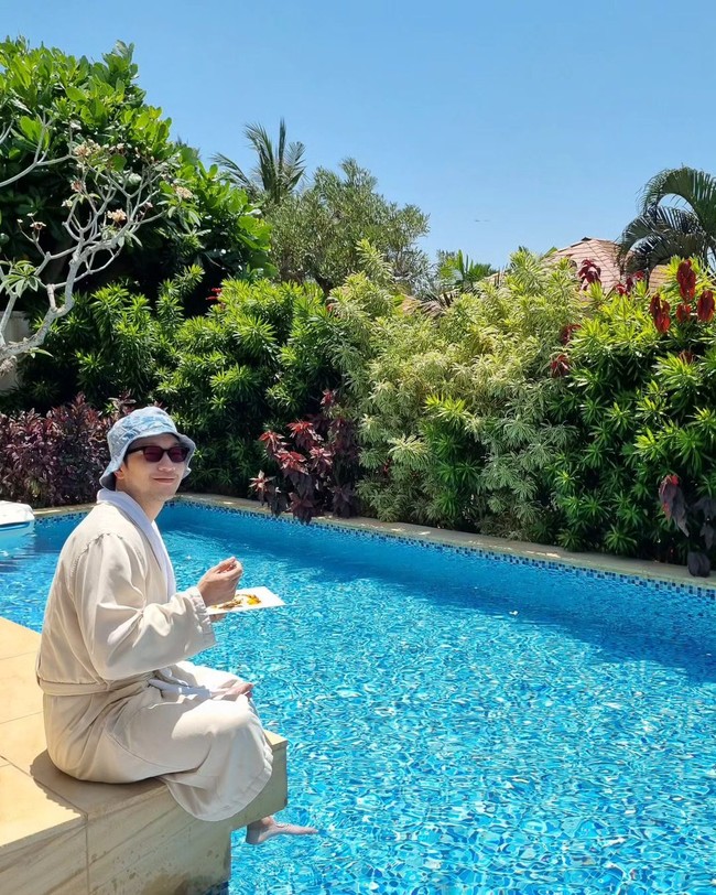 Di foto pertamanya, sang aktor menikmati breakfast di pinggir kolam renang. Son Sukku tampil santai menikmati cuaca terik dan hembusan angin Bali dalam balutan bath robe Hotel Mulia. Tak lupa kacamata hitam dan bucket hat sebagai penangkal panas. Foto: dok. Instagram @sonsukku
