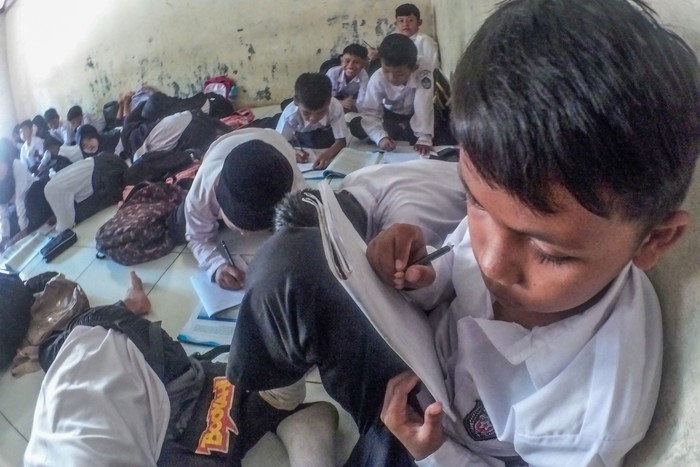 Sejumlah siswa kelas IV SDN Cidokom 02 mengikuti kegiatan belajar di lantai ruangan musholla di Rumpin, Kabupaten Bogor, Jawa Barat , Jumat (6/10/2023). Kegiatan belajar mengajar (KBM) dengan kondisi tanpa meja kursi di sekolah tersebut sudah berlangsung lebih dari dua tahun karena kekurangan ruangan kelas sehingga ruang laboratorium dan musholla digunakan sebagai kelas untuk menampung total 494 siswa. ANTARA FOTO/Yulius Satria Wijaya/nym.