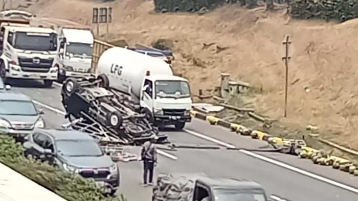 Mobil pikap muatan tabung gas mengalami pecah ban hingga terguling di Tol JORR