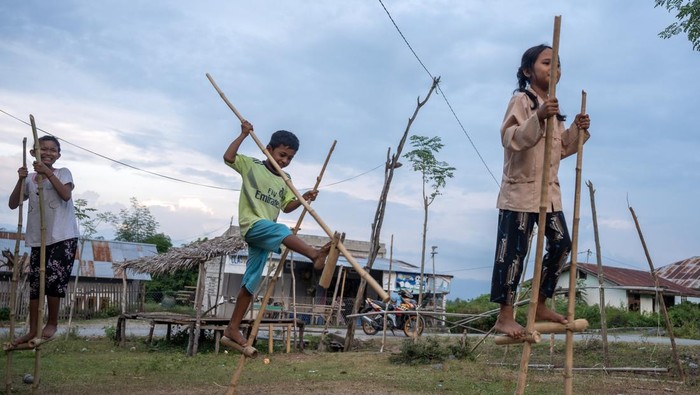 Sejumlah anak bersiap bermain Tilalako atau egrang (engrang) di Desa Balane, Sigi, Sulawesi Tengah, Kamis (5/10/2023). Sebagian anak-anak di wilayah yang terletak di kaki barisan Pegunungan Gawalise itu, masih mempertahankan egrang sebagai permainan tradisional yang umumnya dimainkan oleh anak-anak pada kegiatan-kegiatan tertentu seperti lomba tingkat desa dan peringatan hari besar nasional. ANTARA FOTO/Basri Marzuki/YU