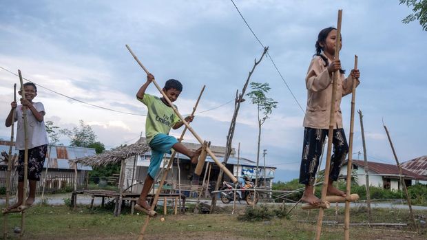 Sejumlah anak bersiap bermain Tilalako atau egrang (engrang) di Desa Balane, Sigi, Sulawesi Tengah, Kamis (5/10/2023). Sebagian anak-anak di wilayah yang terletak di kaki barisan Pegunungan Gawalise itu, masih mempertahankan egrang sebagai permainan tradisional yang umumnya dimainkan oleh anak-anak pada kegiatan-kegiatan tertentu seperti lomba tingkat desa dan peringatan hari besar nasional. ANTARA FOTO/Basri Marzuki/YU