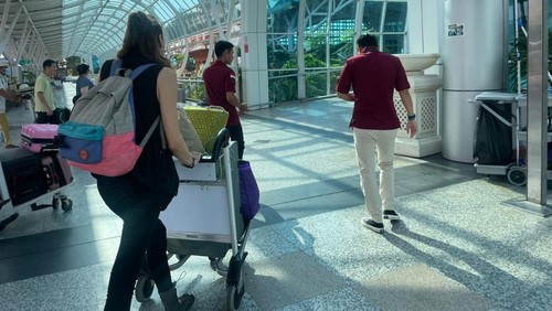 Petugas Imigrasi mengawal bule Rusia berinisial TG saat proses deportasi di Bandara I Gusti Ngurah Rai, Bali, Jumat (6/10/2023). (Foto: Imigrasi Denpasar)