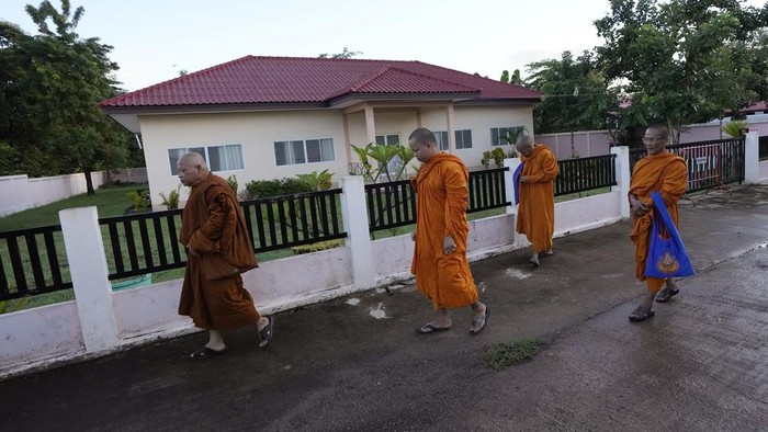 A Buddhist monk splashes holy water to the relatives of the victims during the Buddhist ceremony in the rural town of Uthai Sawan, in Nong Bua Lamphu province, northeastern Thailand, Friday, Oct. 6, 2023. A memorial service takes place to remember those who were killed in a grisly gun and knife attack at a childcare center. A former police officer killed 36 children and teachers in the deadliest rampage in Thailand's history one year ago. (AP Photo/Sakchai Lalit)