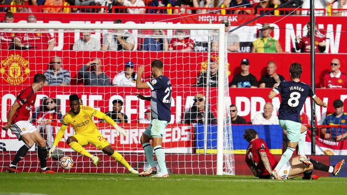 Brentfords Mathias Jensen, right, shoots to score his sides first goal during the English Premier League soccer match between Manchester United and Brentford at the Old Trafford stadium in Manchester, England, Saturday, Oct. 7, 2023.(AP Photo/Jon Super)