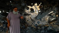 Seorang warga memeriksa sebuah masjid yang hancur akibat serangan Israel di Jalur Gaza. Ibraheem Abu Mustafa/Reuters.