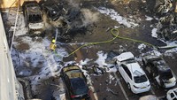 Petugas damkar berusaha memadamkan api yang membakar sejumlah mobil di Ashkelon, Israel. Mobil itu terbakar usai dihantam roket Hamas. AP Photo/Tsafrir Abayov.  