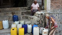 Warga antre mengisi air dari bak penampungan yang debitnya kecil di kawasan lereng pegunungan Menoreh Dusun Butuh, Candirejo, Borobudur, Magelang, Jawa Tengah. 