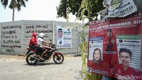 Pengendara melintas di depan tembok yang bertuliskan Sepanjang Tembok Ini Disewakan Bagi Para Bacaleg/Spanduk Partai.  