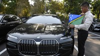 Seorang petugas merapikan bendera kebangsaan Negara Kepulauan Salomon pada mobil listrik di area Sentral Parkir ITDC Nusa Dua, Badung, Bali. 