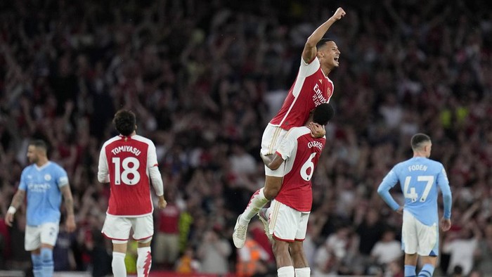 Arsenals William Saliba, top, and Arsenals Gabriel celebrate winning the English Premier League soccer match between Arsenal and Manchester City at the Emirates Stadium in London, Sunday, Oct. 8, 2023.(AP Photo/Kirsty Wigglesworth)