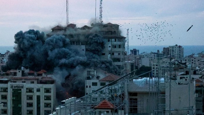 A missile lands as smoke billows while Israeli forces strike a high-rise tower in Gaza City, October 7, 2023. REUTERS/Ahmed Zakot