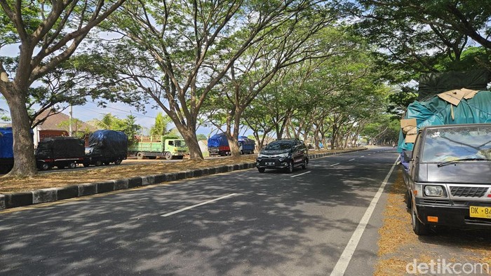 Mobil-mobil pengangkut bahan pokok parkir di pinggir jalan Bypass Ngurah Rai, Klungkung, Senin (9/10/2023).