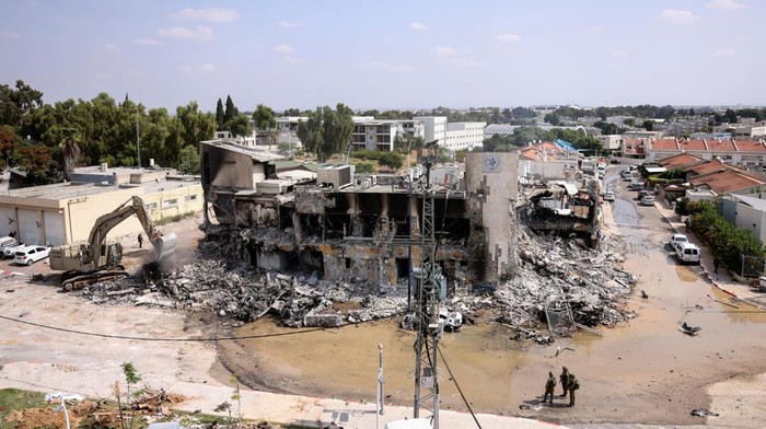 Penampakan Markas Polisi di Israel Hancur Digempur Hamas Israeli security gather near a rifle at the site of a battle following a mass infiltration by Hamas gunmen from the Gaza Strip, in Sderot, southern Israel October 8, 2023. REUTERS/Ronen Zvulun