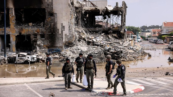 Israeli security gather near a rifle at the site of a battle following a mass infiltration by Hamas gunmen from the Gaza Strip, in Sderot, southern Israel October 8, 2023. REUTERS/Ronen Zvulun