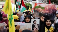 Pendukung Hizbullah Lebanon membawa spanduk selama unjuk rasa untuk mengekspresikan solidaritas terhadap Palestina, di pinggiran selatan Beirut, Lebanon. REUTERS/Emilie Madi.