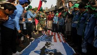 Bendera AS dan Israel terbakar saat pendukung Houthi berunjuk rasa untuk menunjukkan dukungan kepada faksi Palestina. REUTERS/Khaled Abdullah.