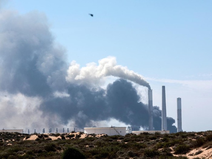 An emergency personnel works to extinguish fire after rockets launched from the Gaza Strip, as seen from the city of Ashkelon, Israel October 7, 2023. REUTERS/Amir Cohen