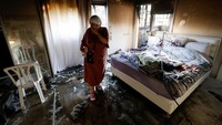 Seorang wanita berdiri di ruangan yang rusak setelah roket diluncurkan dari Jalur Gaza, di Ashkelon, Israel 7 Oktober 2023. REUTERS/Amir Cohen.  