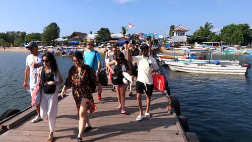 Wisatawan berjalan di dermaga untuk menyeberang ke destinasi wisata Nusa Penida dan Gili Trawangan, NTB  menggunakan kapal cepat di Pelabuhan Serangan, Denpasar, Bali, Jumat (1/9/2023). Pengelola pelabuhan menyebut rata-rata kapal cepat yang berangkat melayani penyeberangan mencapai 27 kapal per hari dengan jumlah penumpang 800-900 orang yang didominasi wisatawan dari China, India dan Eropa. ANTARA FOTO/Nyoman Hendra Wibowo/rwa.