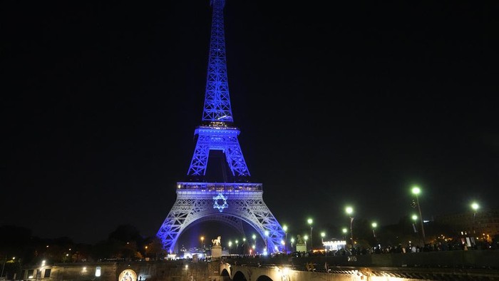 The Eiffel Tower is illuminated with the colors of Israel after a demonstration in a show of support for Israel, Monday, Oct. 9, 2023 in Paris, two days after Hamas fighters launched an unprecedented, multi-front attack on Israel which killed more than 700 people. (AP Photo/Michel Euler)
