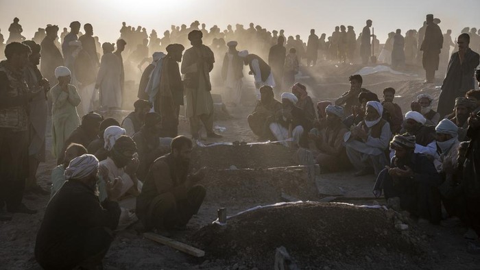 Duka Warga Afghanistan Saat Pemakaman Massal Ribuan Korban Gempa Afghans bury hundreds of people killed in an earthquake at a burial site, outside a village in Zenda Jan district in Herat province, western of Afghanistan, Monday, Oct. 9, 2023. Saturday's deadly earthquake killed and injured thousands when it leveled an untold number of homes in Herat province. (AP Photo/Ebrahim Noroozi)