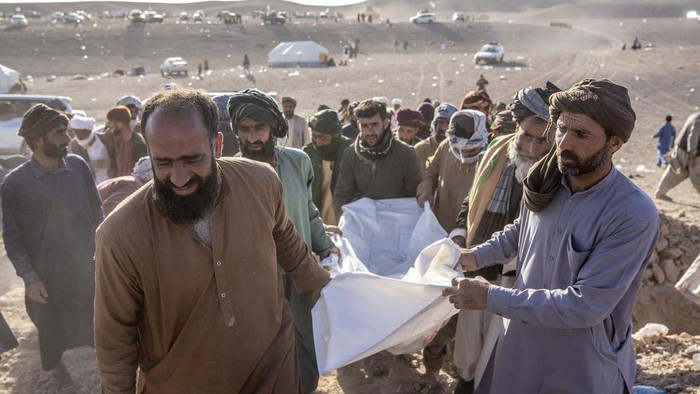 Duka Warga Afghanistan Saat Pemakaman Massal Ribuan Korban Gempa Afghans bury hundreds of people killed in an earthquake at a burial site, outside a village in Zenda Jan district in Herat province, western of Afghanistan, Monday, Oct. 9, 2023. Saturday's deadly earthquake killed and injured thousands when it leveled an untold number of homes in Herat province. (AP Photo/Ebrahim Noroozi)