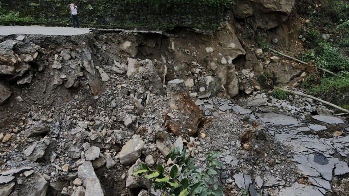 INDIA-FLOODS/ A man takes pictures of roads damaged by flash floods in Naga-Namgor village, Sikkim, India, October 10, 2023. REUTERS/Francis Mascarenhas