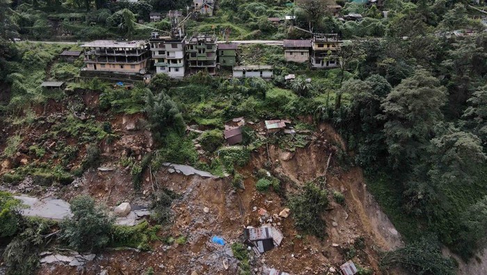 INDIA-FLOODS/ A man takes pictures of roads damaged by flash floods in Naga-Namgor village, Sikkim, India, October 10, 2023. REUTERS/Francis Mascarenhas