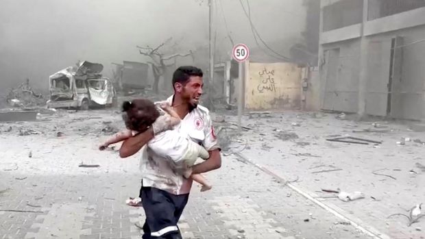 A medic runs as he carries an injured Palestinian child to ambulance in this screengrab taken from a video, in Gaza, October 9, 2023. REUTERS/Stringer NO RESALES. NO ARCHIVES TPX IMAGES OF THE DAY