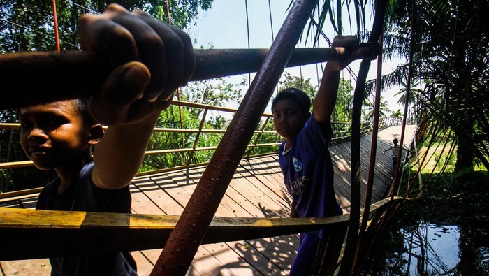 Jembatan gantung ambruk Tiga anak bergantungan di besi saat melewati jembatan gantung yang terputus di Desa Alue Keujruen, Kecamatan Tanah Luas, Aceh Utara, Aceh. Selasa (10/10/2023). Putus dan ambruknya jembatan gantung penghubung enam kecamatan tersebut dikarenakan kondisi rekontruksi tua sehingga tidak mampu menahan beban berat kenderaan roda empat yang kerap melewati jembatan tersebut. ANTARA FOTO/Rahmad/YU
