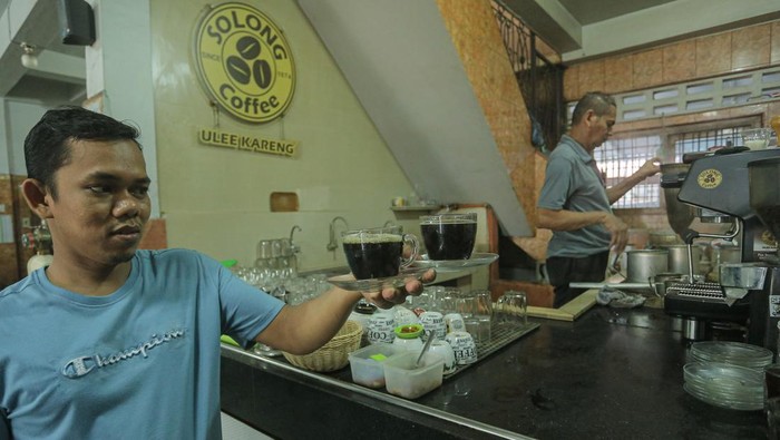 Kongkow di Warung Kopi Solong, Kedai Favorit Orang Aceh Seorang pekerja di warung kopi Solong menyaring kopi untuk disajikan kepada pengunjung di kawasan Ulee Kareng, Banda Aceh, Aceh, Senin (9/10/2023). Warung kopi Solong didirikan pada 1974 oleh Muhammad Saman atau akrab disapa Abu Solong dan kini dikelola generasi kedua dengan tetap menyajikan kopi robusta khas Aceh secara tradisional untuk wisatawan lokal maupun mancanegara. ANTARA FOTO/Khalis Surry/nz