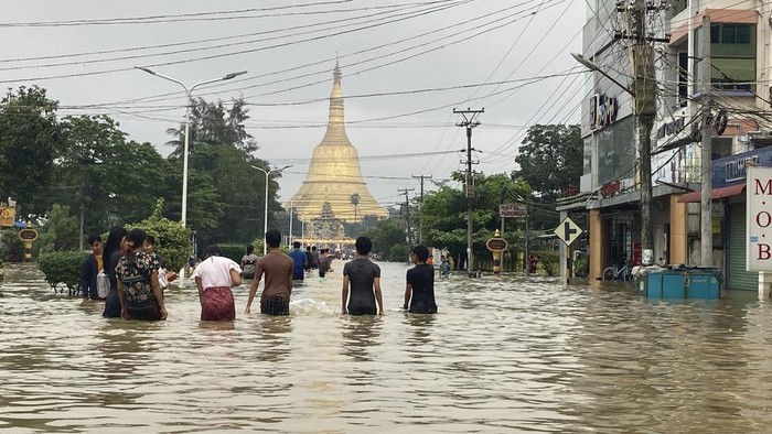Myanmar Dilanda Banjir, Belasan Ribu Orang Mengungsi Local residents wade through a flooded road in Bago, about 80 kilometers (50 miles) northeast of Yangon, Myanmar, Monday, Oct.9, 2023. Flooding triggered by heavy monsoon rains in Myanmarβs southern areas has displaced more than 10,000 people and disrupted traffic on the rail lines that connect the countryβs biggest cities, officials and state-run media said Monday. (AP Photo/Thein Zaw)