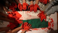 Di Chili, anak-anak pun turut melakukan aksi mendukung Palestina. Dalam aksinya, mereka mewarnai telapak tangannya dengan warna merah. Reuters/Ivan Alvarado.