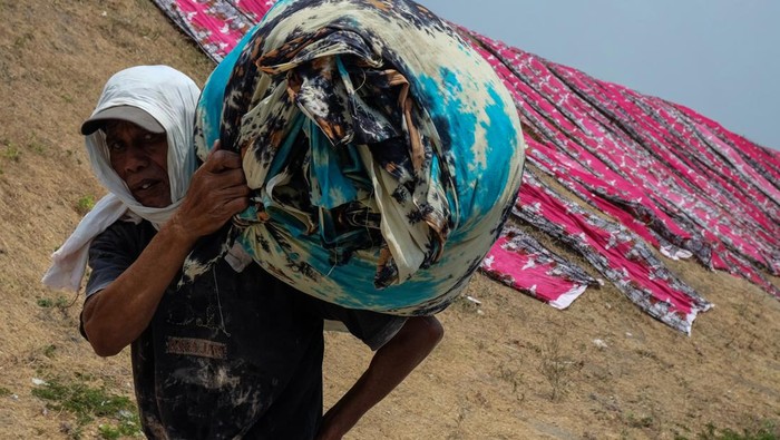 Pekerja menjemur kain pantai di sentra industri rumahan Desa Krajan, Mojolaban, Sukoharjo, Jawa Tengah, Selasa (10/10/2023). Selain dipasarkan di kawasan wisata domestik, produk kerajinan kain pantai di sentra industri setempat juga untuk memenuhi permintaan pasar di negara Brazil, Argentina, Malaysia, Filipina, dan China. ANTARAFOTO/Maulana Surya/Spt.