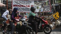 Spanduk tersebut bertuliskan Kami Seluruh Warga, Pengurus RW dan RT di Wilayah RW 06 Mendesak !!! Agar Proyek Drainase di Jalan Asem Baris Raya Segera Diselesaikan.