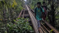 Anak-anak berjalan di jembatan jalur kereta api Rangkasbitung-Labuan di Saketi, Pandeglang, Banten, Senin (9/10/2023).  