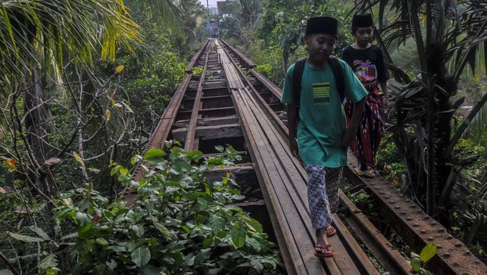 Warga berjalan di jembatan jalur kereta api Rangkasbitung-Labuan di Saketi, Pandeglang, Banten, Senin (9/10/2023). Pemerintah menunda rencana reaktivasi jalur kereta api Rangkasbitung-Labuan pada tahun ini dan akan dimulai kembali pada tahun 2025. ANTARA FOTO/Muhammad Bagus Khoirunas/aww.
