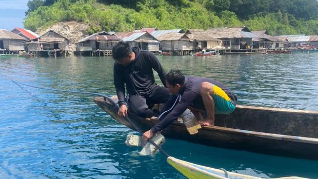 Sertu Faldi Canu memasang aliran air bersih bersama warga Pulau Enam, Tojo Una-una