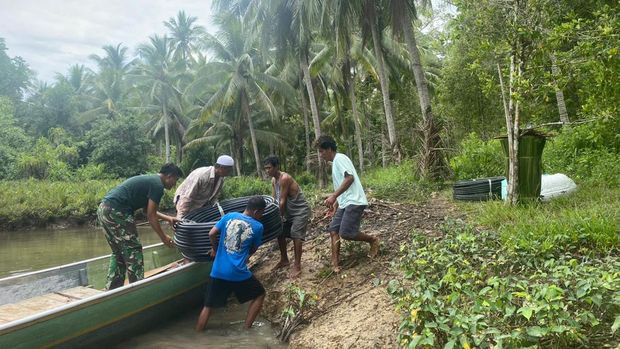 Sertu Faldi Canu memasang aliran air bersih bersama warga Pulau Enam, Tojo Una-una