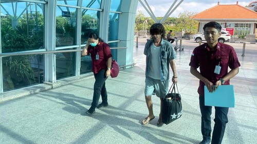Petugas imigrasi mengawal kepulangan warga Turki, MB, dari Bandara Internasional Ngurah Rai, Bali. MB diusir setelah menjalani 2 tahun penjara terkait kasus skimming ATM.