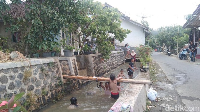 Anak-anak tengah mandi di saluran irigasi Desa Cieurih, Majalengka